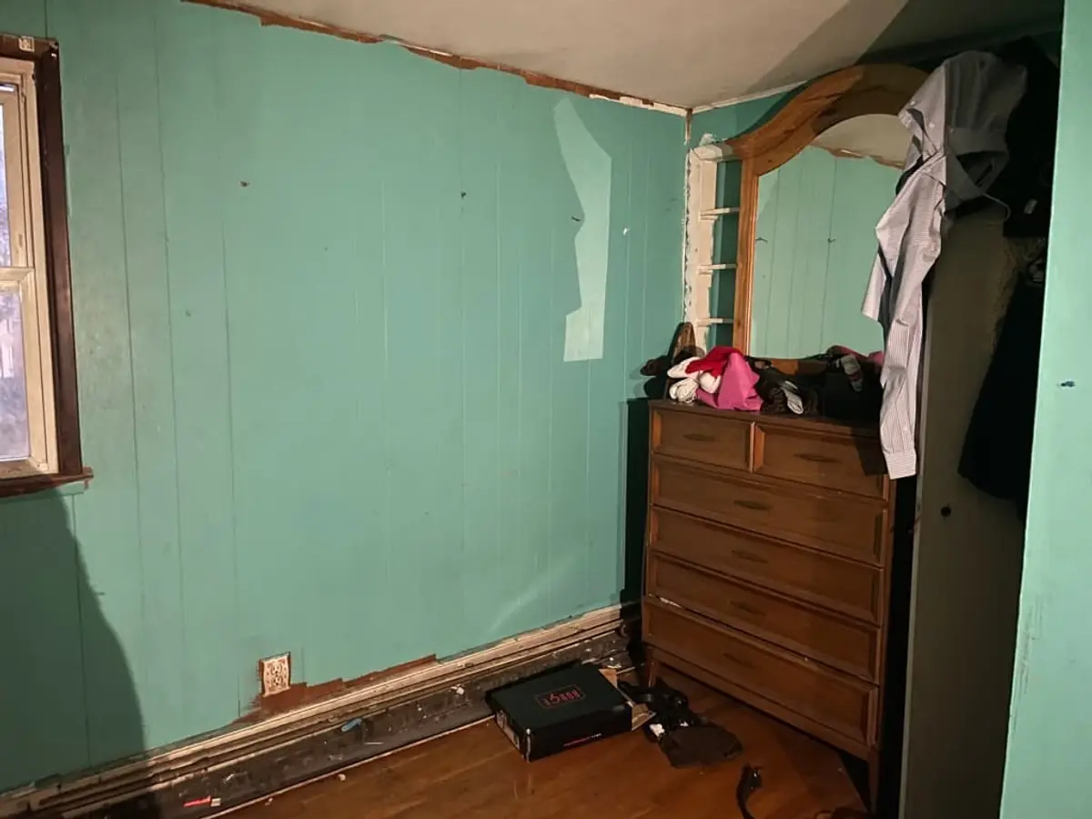 Selling in the Centereach housing market: bedroom with water-damaged trim along the floor