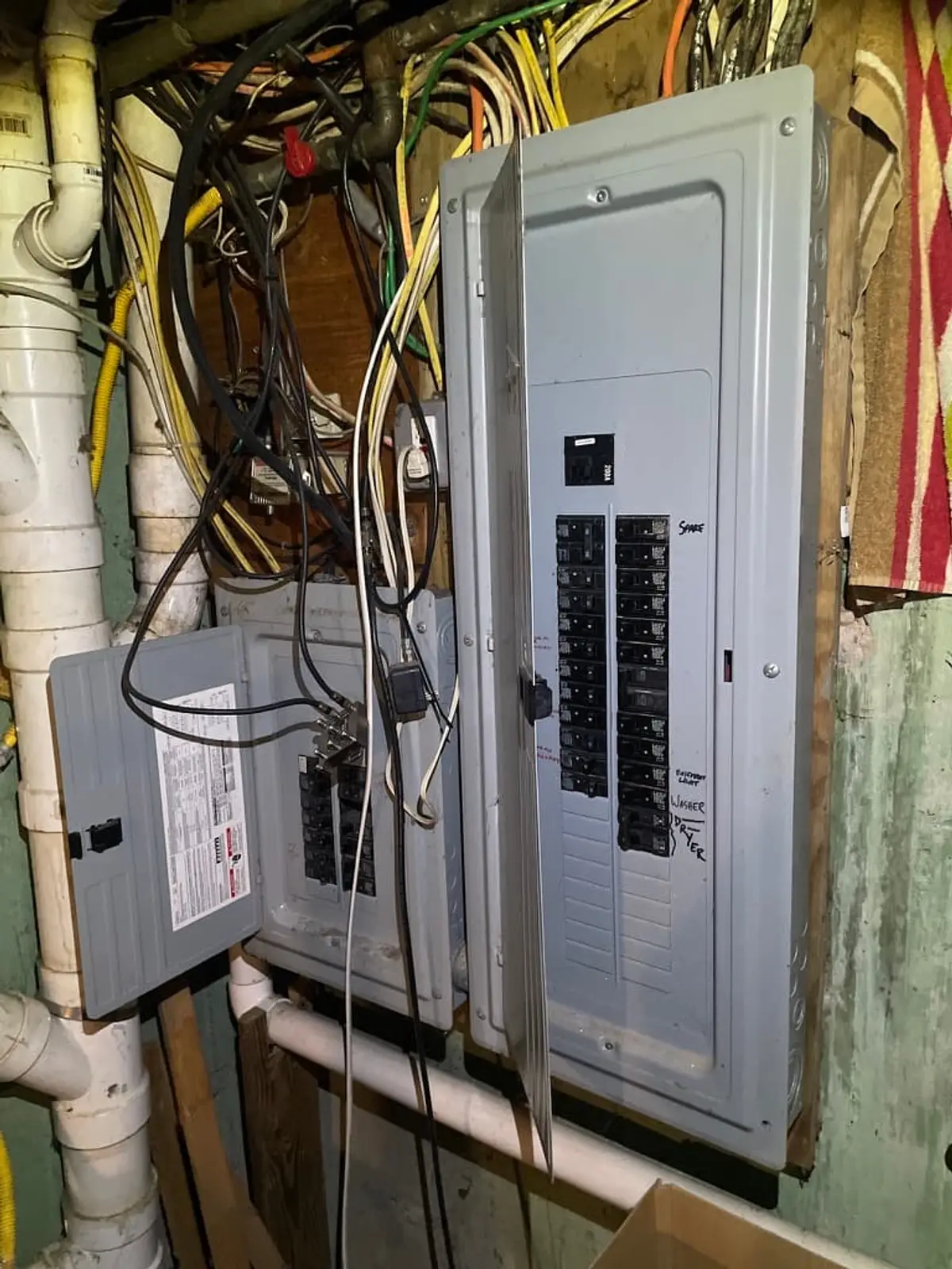 Selling a house with code violations in Centereach: electrical panel with tangled wiring beside it