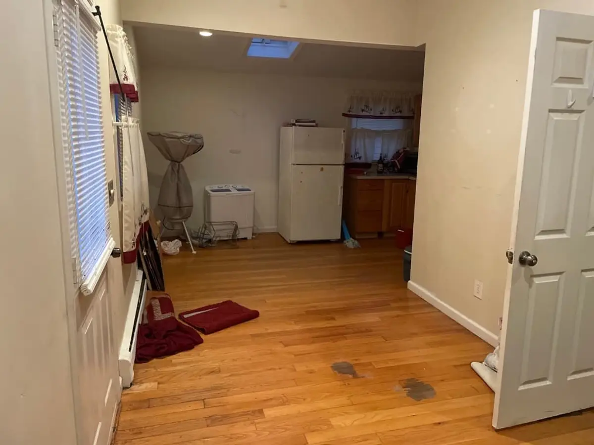 Selling a rental property in Centereach: empty room with a skylight and wood floors