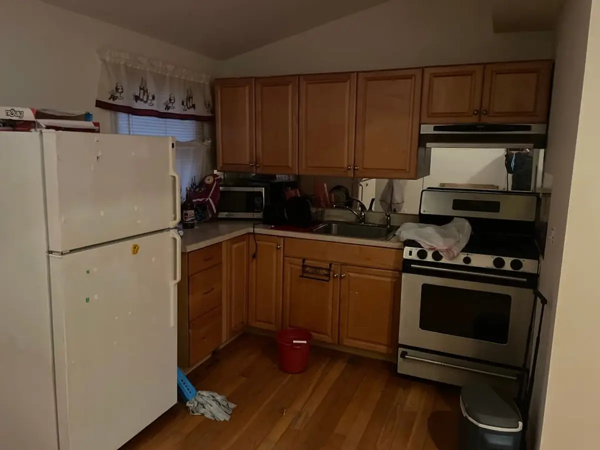 Behind on mortgage payments in Centereach: kitchen with oak cabinets and white appliances
